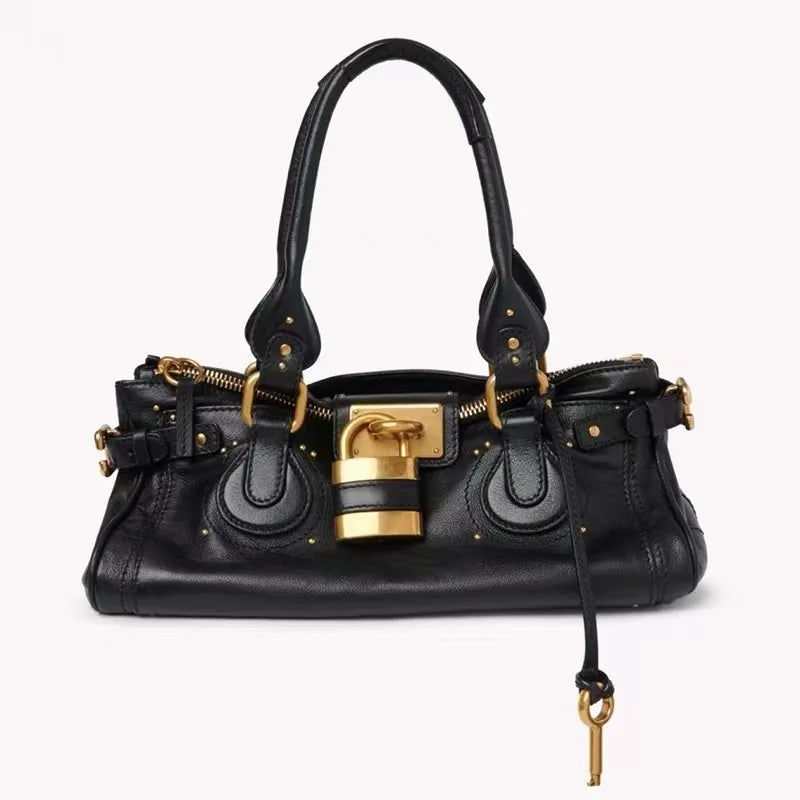 Black handbag with gold accents on a white background
