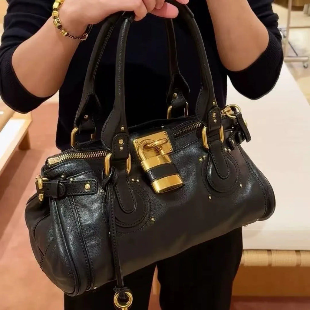 Bolso de mano estilo Paddington con asa superior y cierre dorado, diseño de lujo.