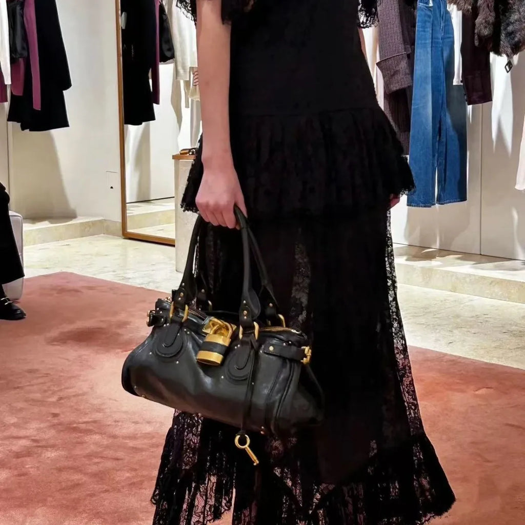 Bolso de mano estilo Paddington con asa superior y cierre dorado, diseño de lujo.