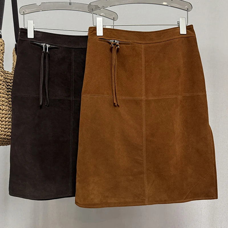 Deep Brown and Caramel brown suede skirts hanging on a rack against a white background