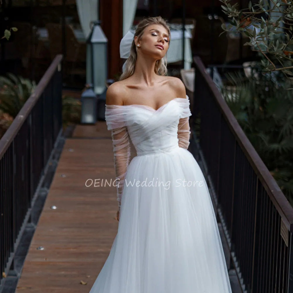 Elegante vestido de novia con chaqueta, hombros descubiertos, mangas largas, corte A, espalda descubierta, tul blanco.