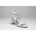 White sandal with crystal embellishments on a lace background