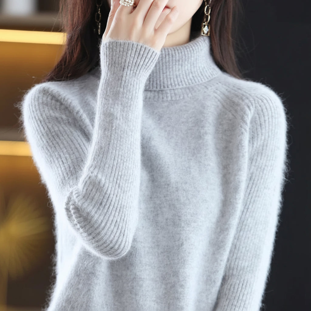 A woman wearing a light gray ribbed turtleneck sweater.