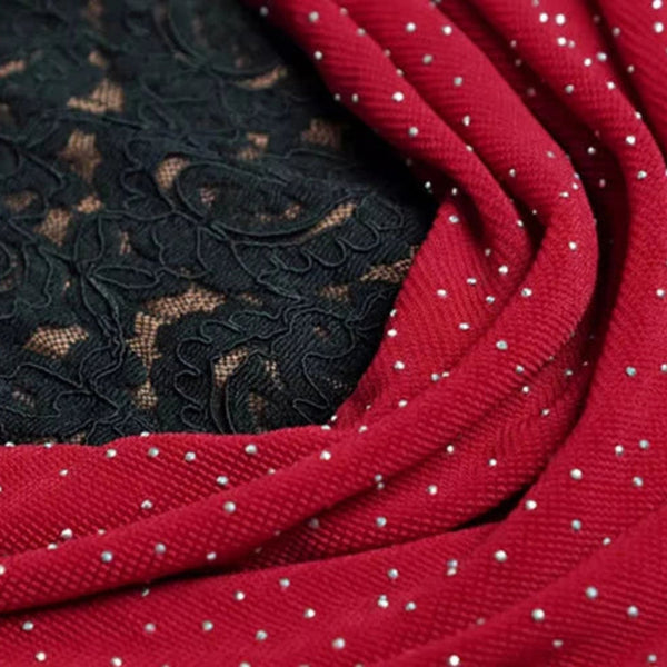 Close-up of black lace fabric and red metal studs fabric